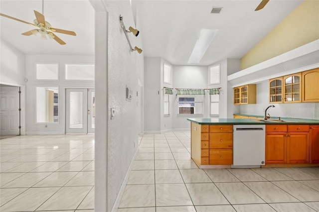 kitchen with dishwasher, light tile patterned floors, a healthy amount of sunlight, and a high ceiling