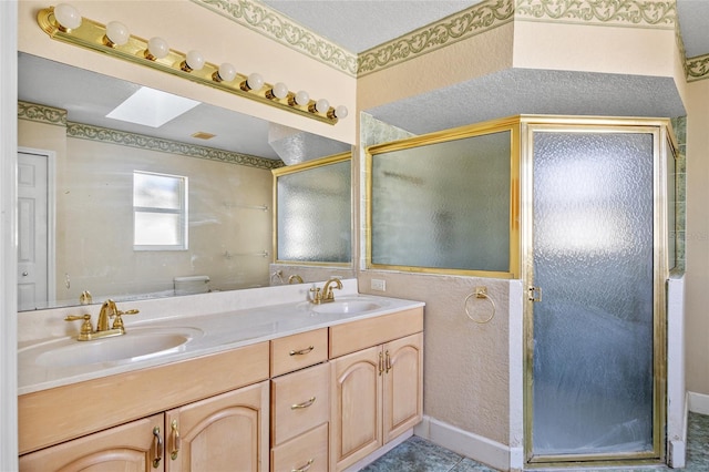 bathroom featuring vanity, a skylight, toilet, and an enclosed shower