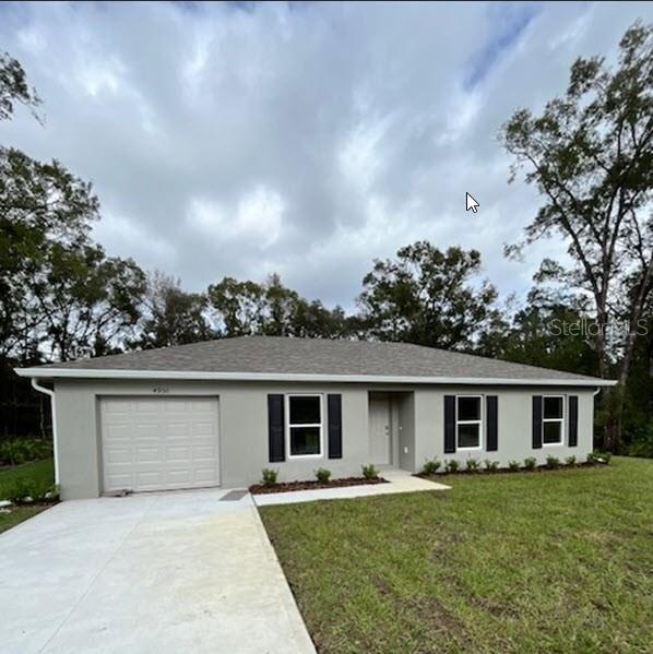 ranch-style home with a garage and a front lawn