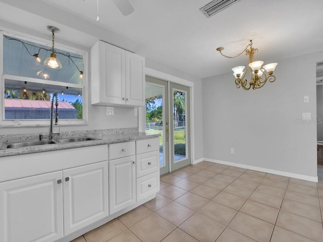 kitchen featuring ceiling fan with notable chandelier, sink, decorative light fixtures, light tile patterned flooring, and white cabinetry