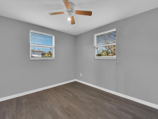 unfurnished room with ceiling fan and dark hardwood / wood-style flooring