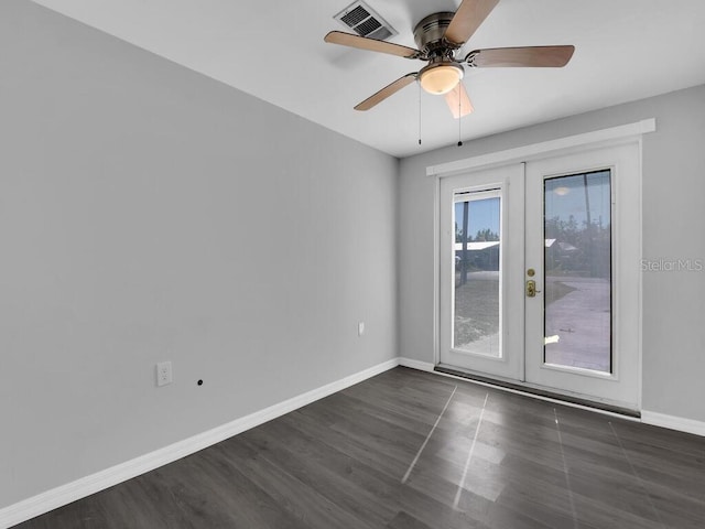 empty room with ceiling fan, dark hardwood / wood-style flooring, and french doors