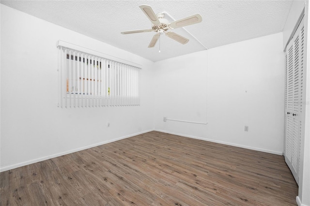 unfurnished bedroom with ceiling fan, dark wood-type flooring, a textured ceiling, and a closet