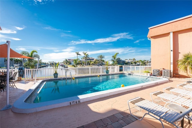 view of pool featuring a water view and a patio area