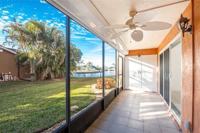 unfurnished sunroom with a water view and ceiling fan