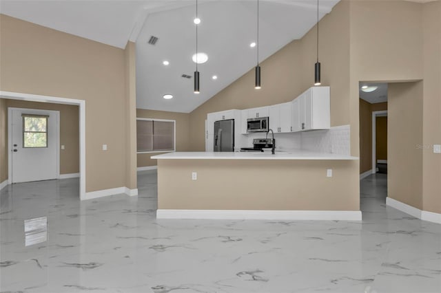 kitchen featuring appliances with stainless steel finishes, white cabinetry, high vaulted ceiling, kitchen peninsula, and pendant lighting