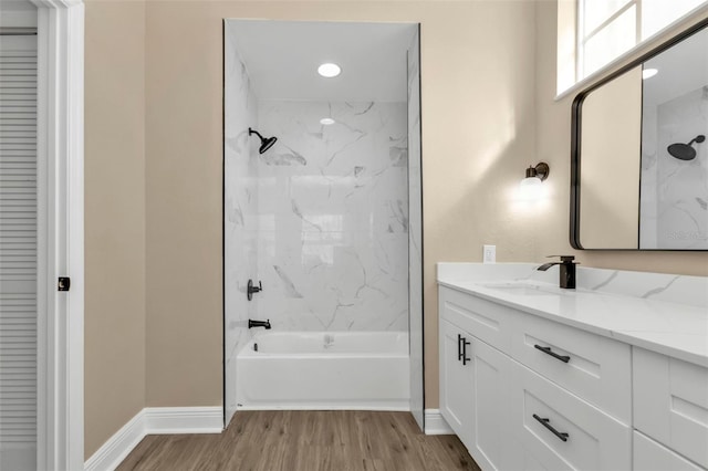 bathroom with tiled shower / bath combo, hardwood / wood-style flooring, and vanity