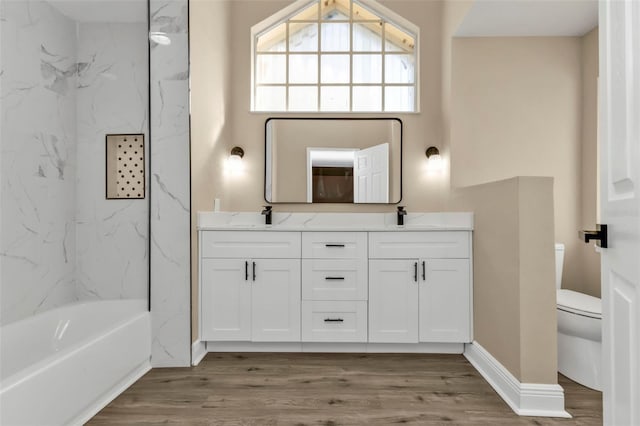 bathroom with vanity, toilet, hardwood / wood-style floors, and a tub to relax in