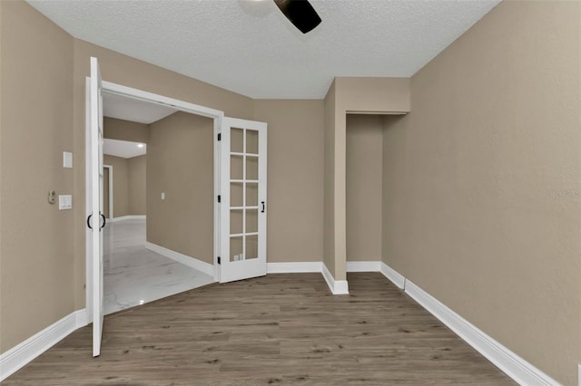 unfurnished room with wood-type flooring, a textured ceiling, and ceiling fan