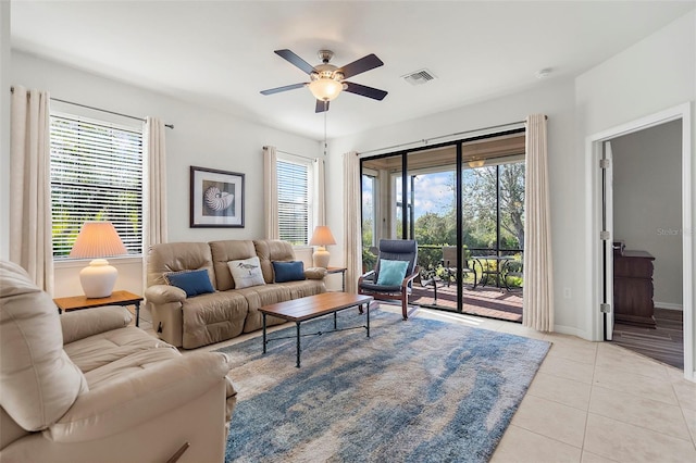 tiled living room with a wealth of natural light and ceiling fan