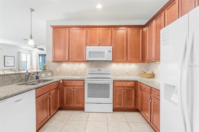 kitchen featuring ceiling fan, sink, light stone counters, white appliances, and decorative backsplash