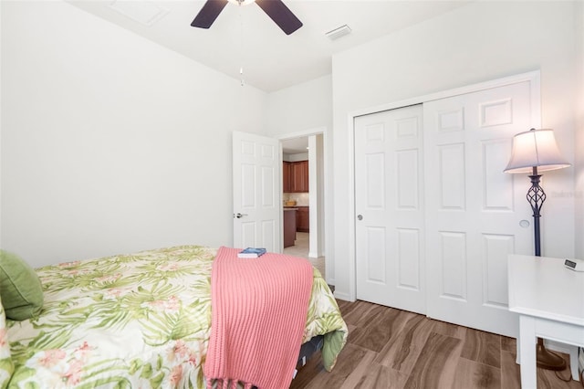 bedroom featuring hardwood / wood-style flooring, ceiling fan, and a closet