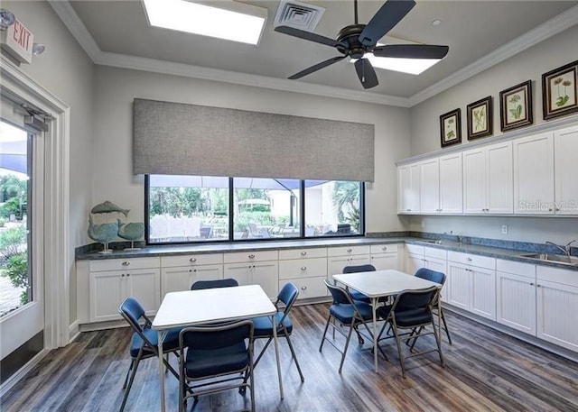 kitchen with dark wood-style floors, visible vents, white cabinetry, and ornamental molding