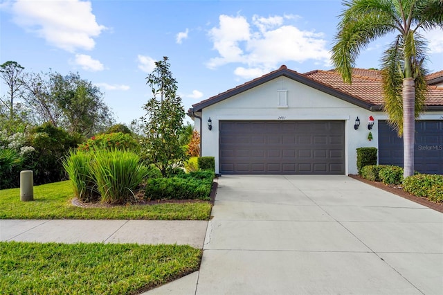 view of front facade featuring stucco siding, a garage, driveway, and a tiled roof