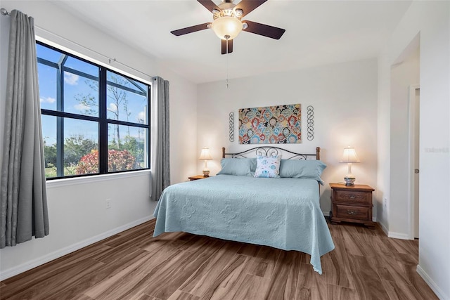 bedroom with wood finished floors, baseboards, and ceiling fan