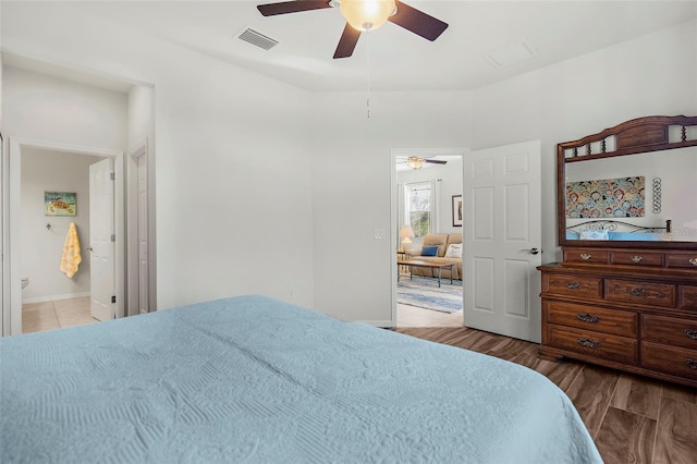 bedroom with ceiling fan, visible vents, connected bathroom, and wood finished floors