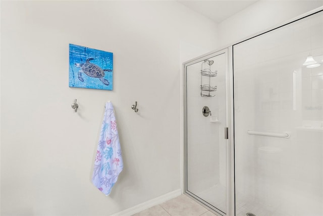 bathroom with tile patterned floors, a shower stall, and baseboards