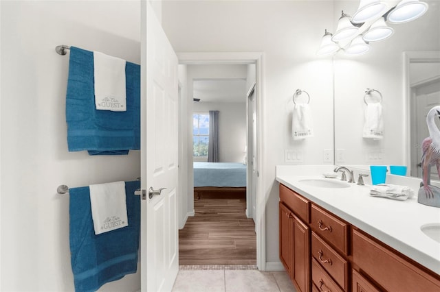 bathroom with a sink, double vanity, ensuite bathroom, and tile patterned flooring