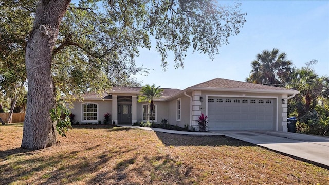 ranch-style home featuring a garage, a front yard, driveway, and stucco siding