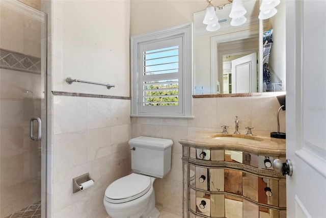 bathroom featuring vanity, a shower with shower door, tile walls, and toilet