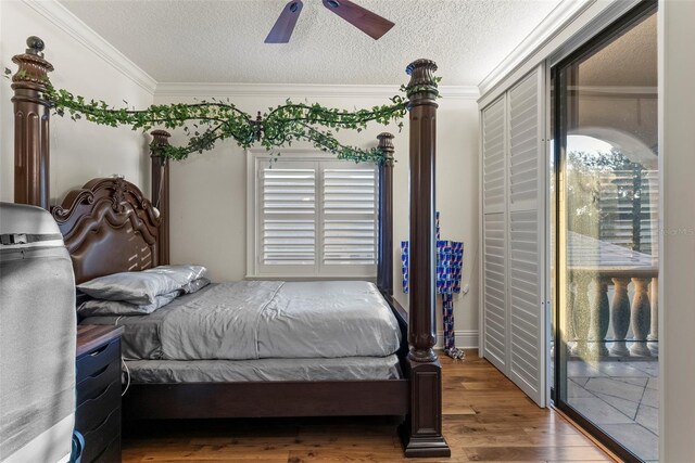 bedroom featuring hardwood / wood-style floors, access to outside, ceiling fan, ornamental molding, and a textured ceiling