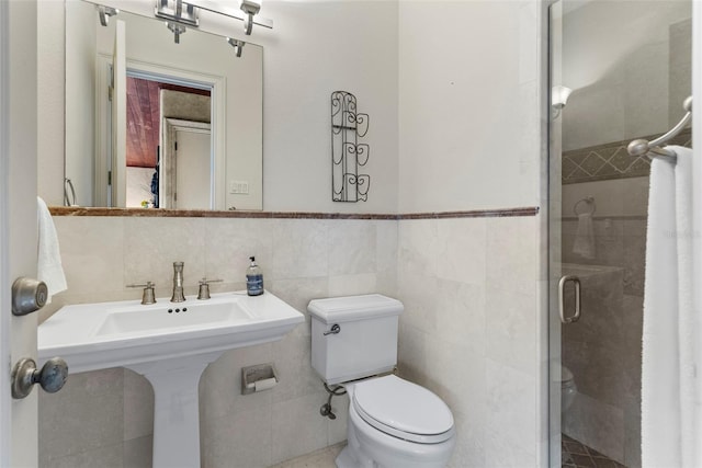 bathroom with sink, toilet, tile walls, and walk in shower