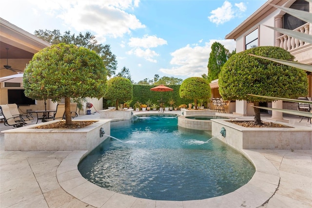 view of pool featuring pool water feature, an in ground hot tub, and a patio