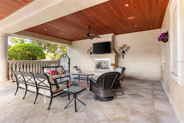 view of patio with an outdoor living space with a fireplace and ceiling fan