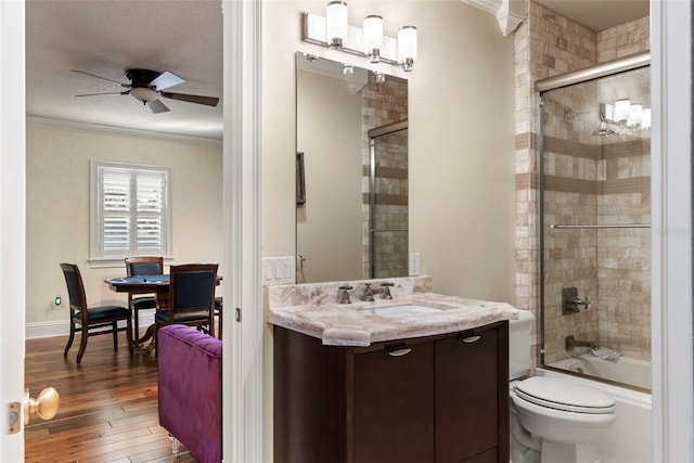 full bathroom with ceiling fan, bath / shower combo with glass door, wood-type flooring, a textured ceiling, and ornamental molding