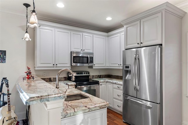 kitchen featuring pendant lighting, white cabinets, ornamental molding, kitchen peninsula, and stainless steel appliances