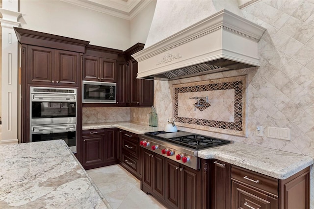 kitchen with stainless steel appliances, light stone counters, decorative backsplash, custom range hood, and ornamental molding