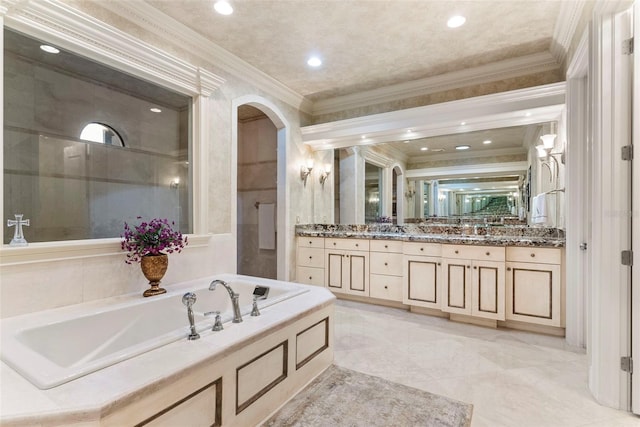 bathroom featuring a bathing tub, vanity, and crown molding