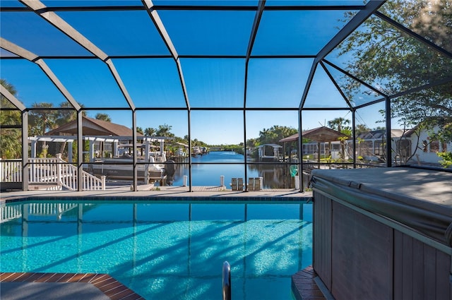 view of pool featuring glass enclosure and a water view