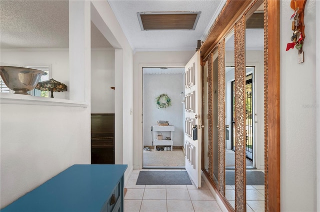 corridor featuring a textured ceiling, plenty of natural light, light tile patterned floors, and crown molding