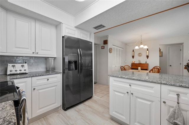 kitchen with fridge with ice dispenser, an inviting chandelier, backsplash, white cabinets, and range