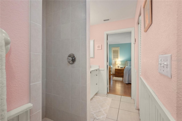 bathroom with a tile shower, hardwood / wood-style floors, and vanity