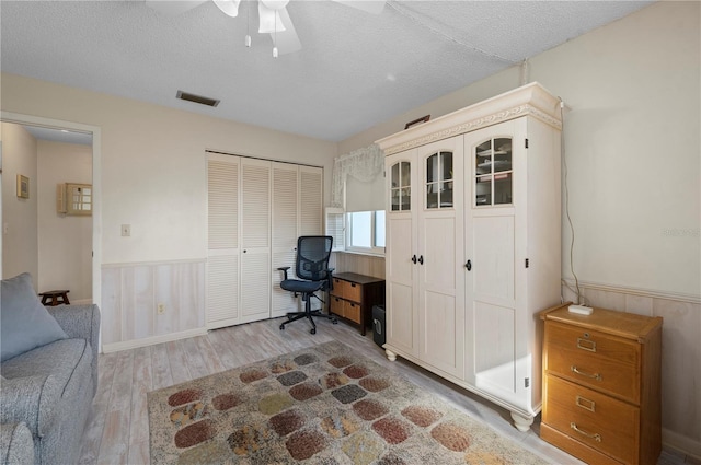 office space featuring ceiling fan, a textured ceiling, and light wood-type flooring