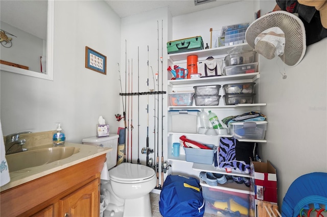 bathroom featuring tile patterned flooring, vanity, and toilet