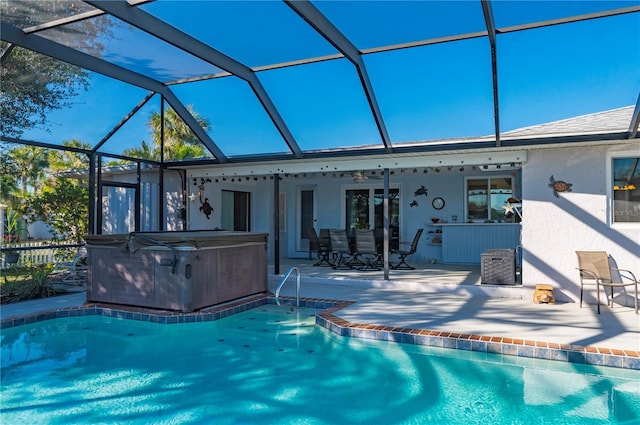 view of swimming pool featuring a patio, glass enclosure, and a hot tub