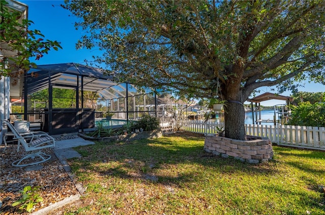 view of yard with a water view and glass enclosure