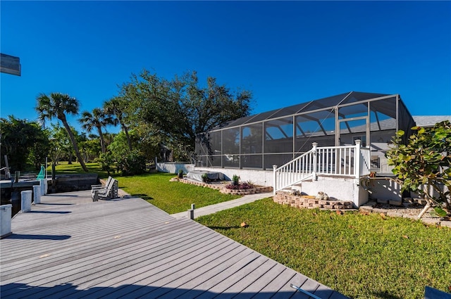 wooden deck with a lanai and a lawn