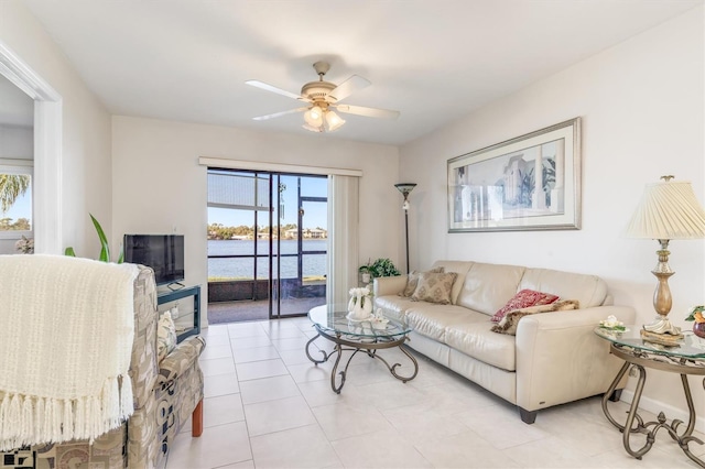 living room featuring ceiling fan, light tile patterned floors, and a healthy amount of sunlight