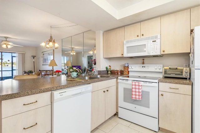 kitchen with ceiling fan with notable chandelier, light tile patterned floors, white appliances, and sink