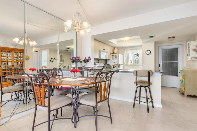 tiled dining area featuring a notable chandelier