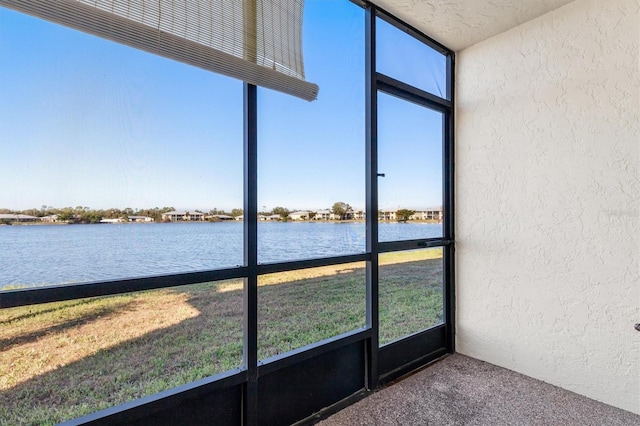 unfurnished sunroom featuring a water view and a wealth of natural light