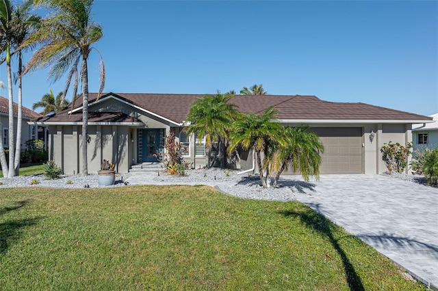 view of front of home with a front yard and a garage