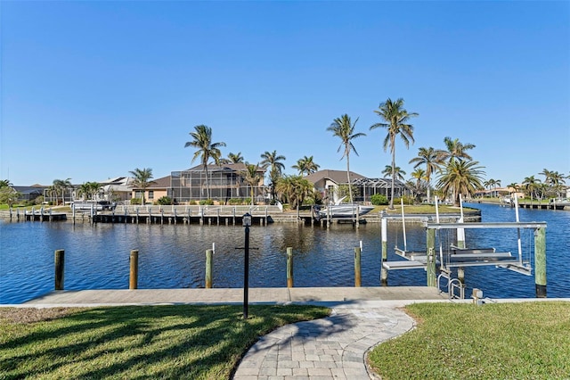 view of dock with a water view and a lawn