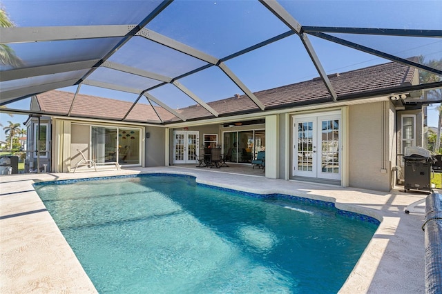 view of swimming pool featuring french doors, ceiling fan, a lanai, area for grilling, and a patio area