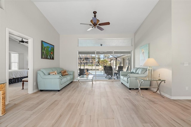 living room featuring ceiling fan, lofted ceiling, and light wood-type flooring