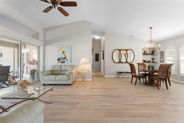 living room featuring a wealth of natural light, light hardwood / wood-style flooring, ceiling fan with notable chandelier, and lofted ceiling